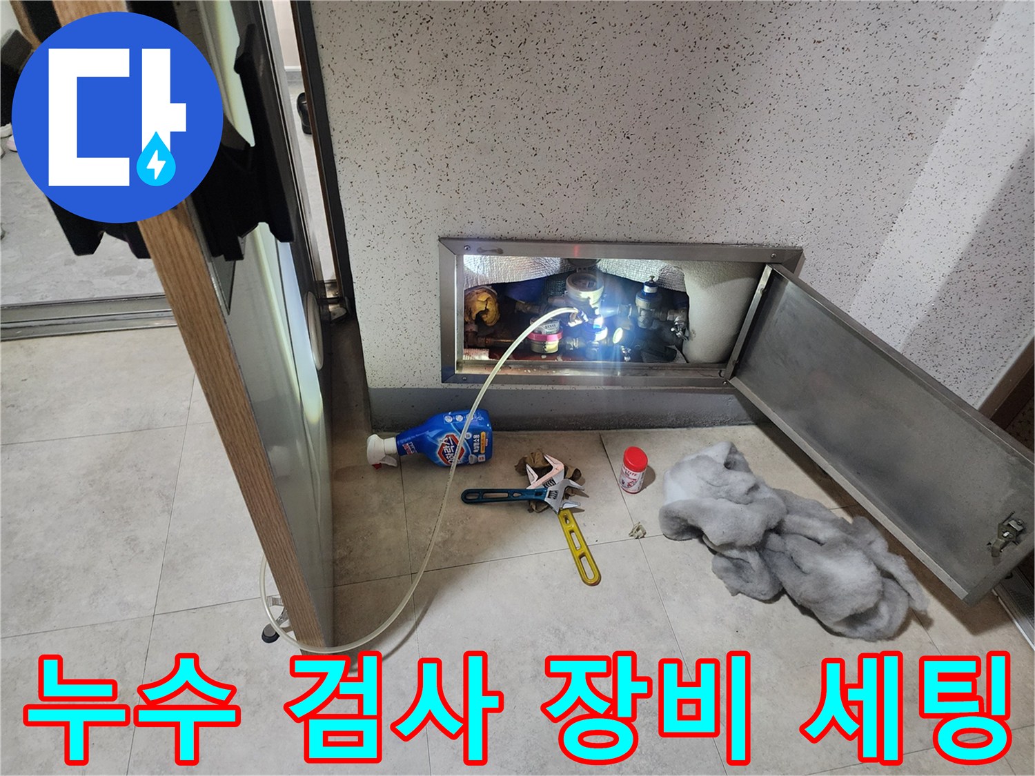 배관 점검구 주변에 배치된 공압 테스트 장비와 도구들입니다.