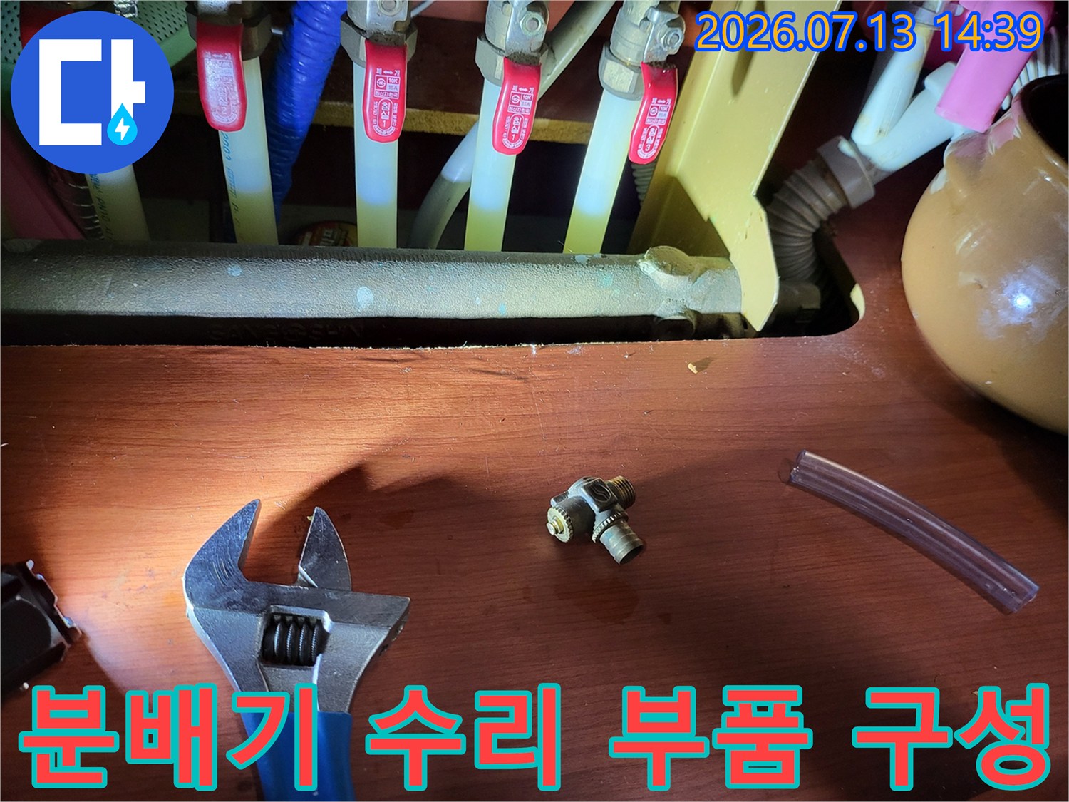 금속-T자형-연결부속과-파란색-몽키스패너가-함께-놓여있는-모습
