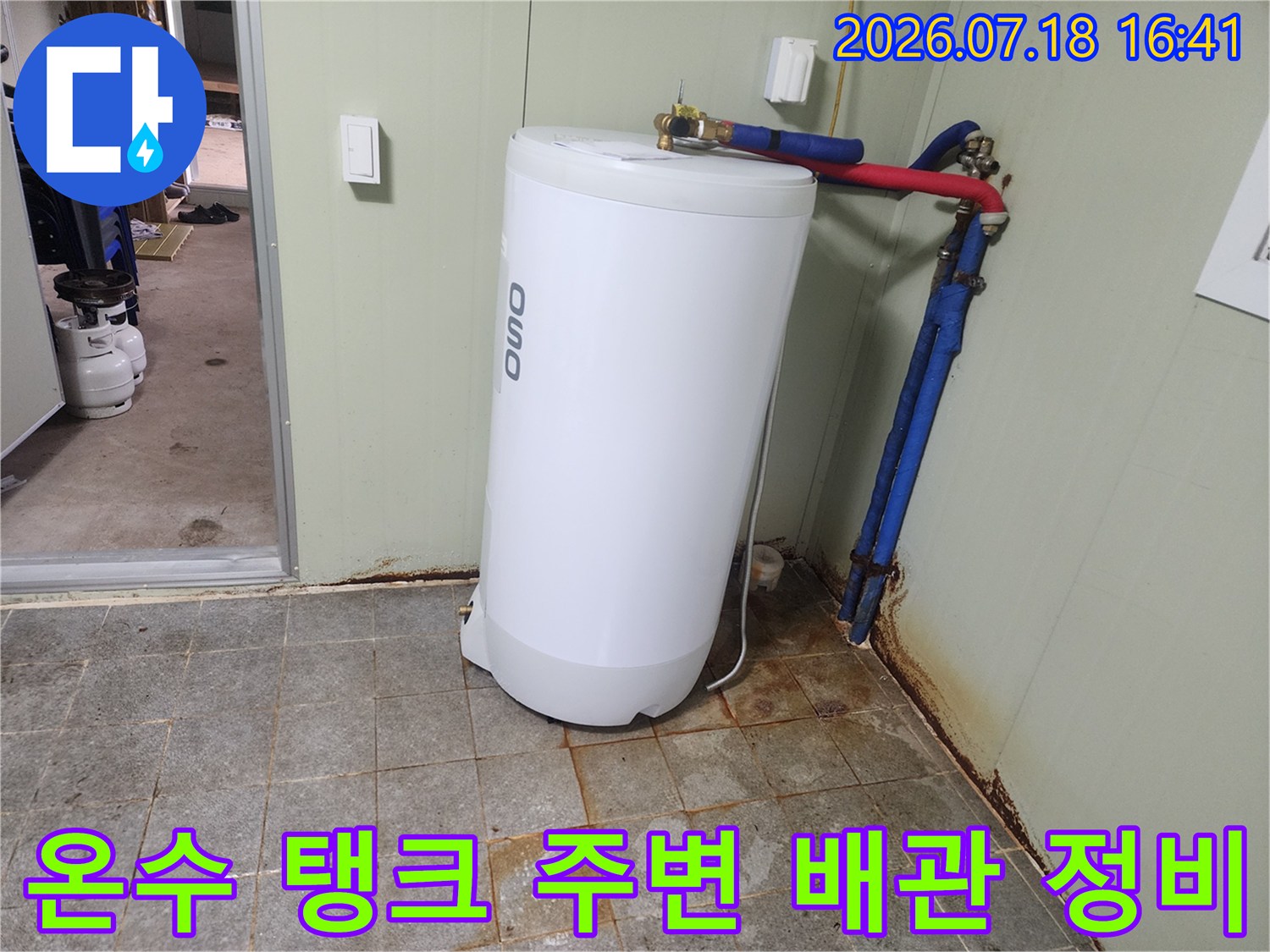 대형 온수탱크 옆에 설치된 파란색과 빨간색의 복합 배관망