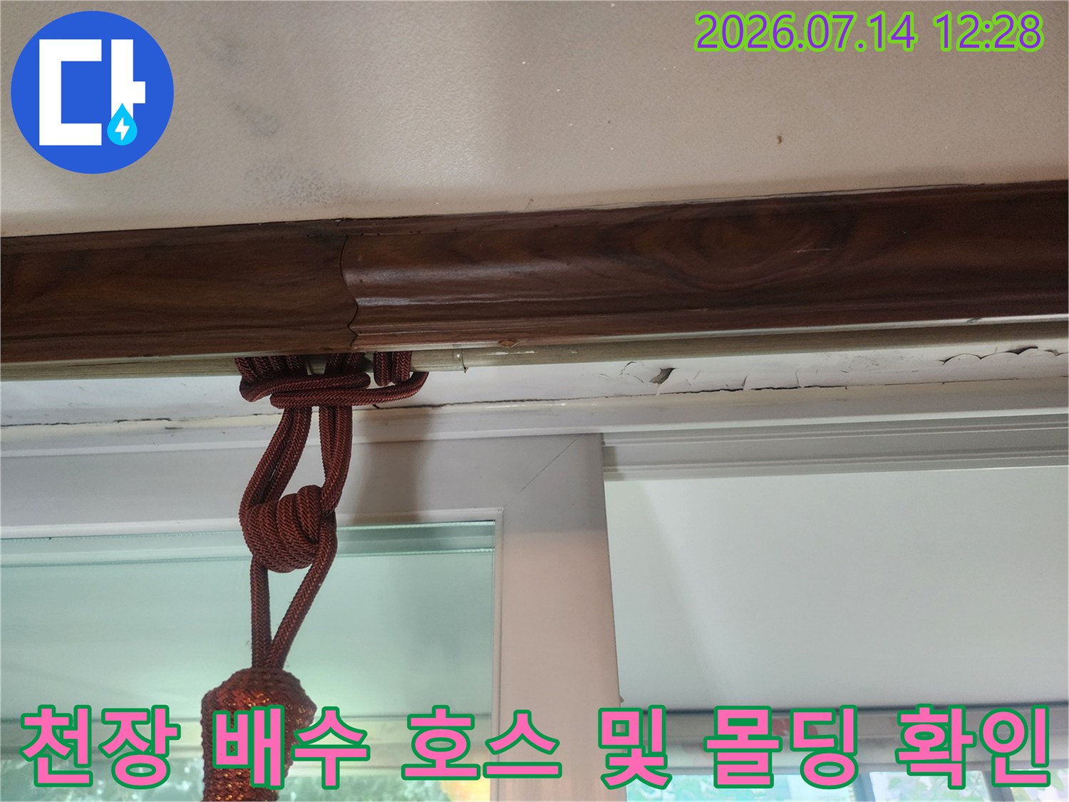 배수용 드레인 호스와 연결된 천장 목재 몰딩의 누수 징후 사진