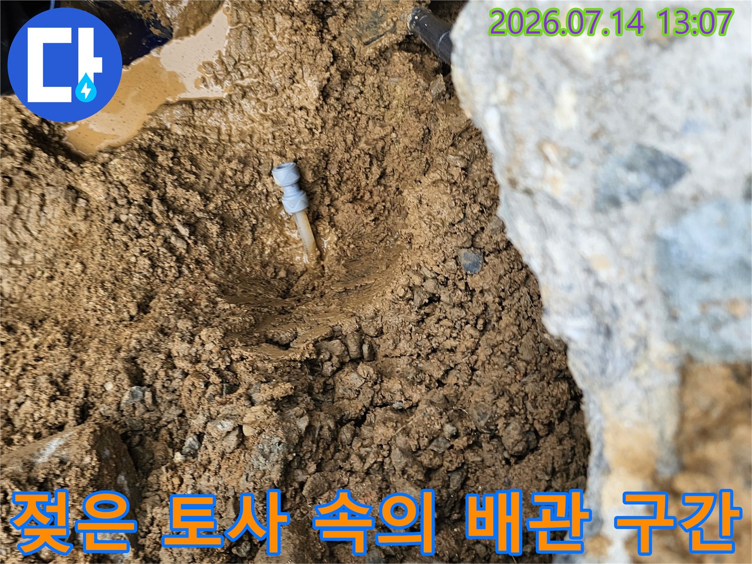 물기로 젖어 있는 지면과 노출된 파손 배관 부위