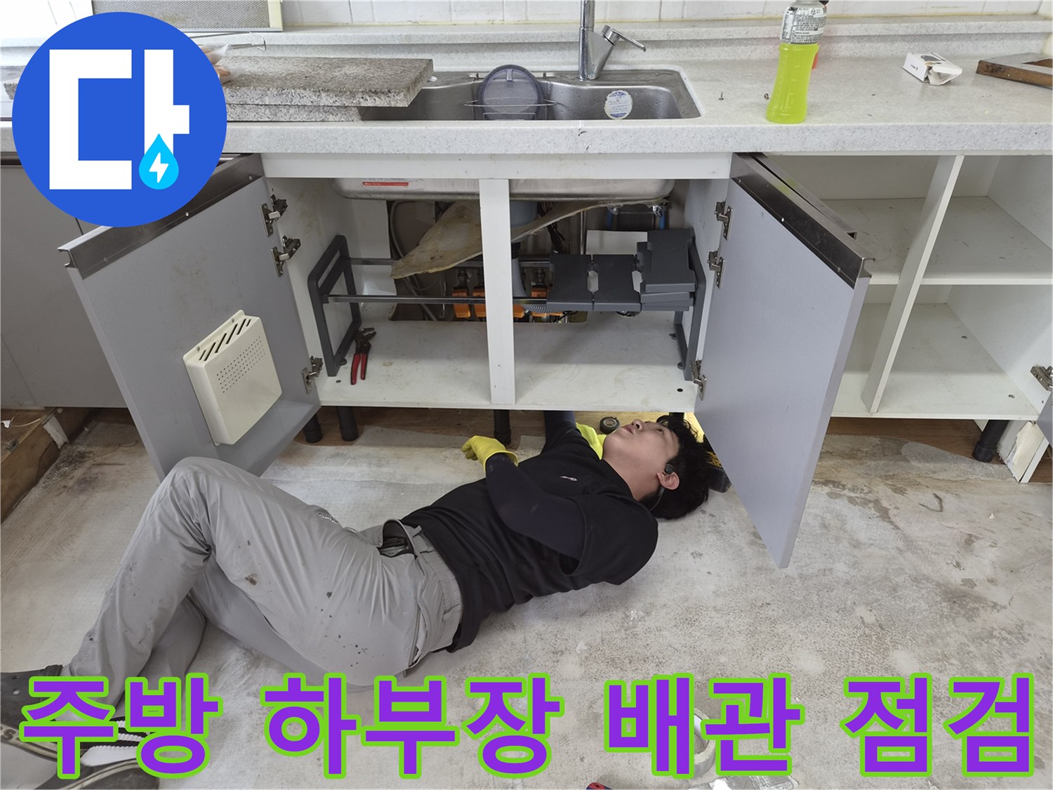 싱크대 아래쪽 배관 상태를 확인하며 누수를 진단하는 모습