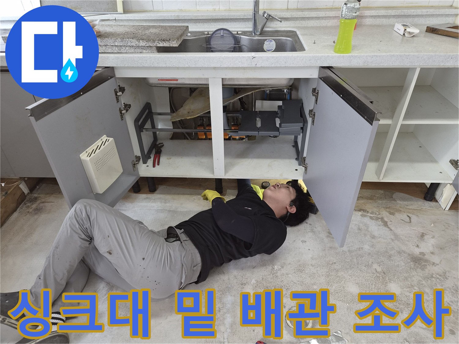 좁은 싱크대 하부 공간에서 작업 중인 엔지니어