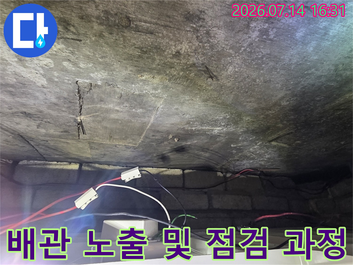 화장실 천장 내부 배관과 테스트용 호스가 연결된 모습