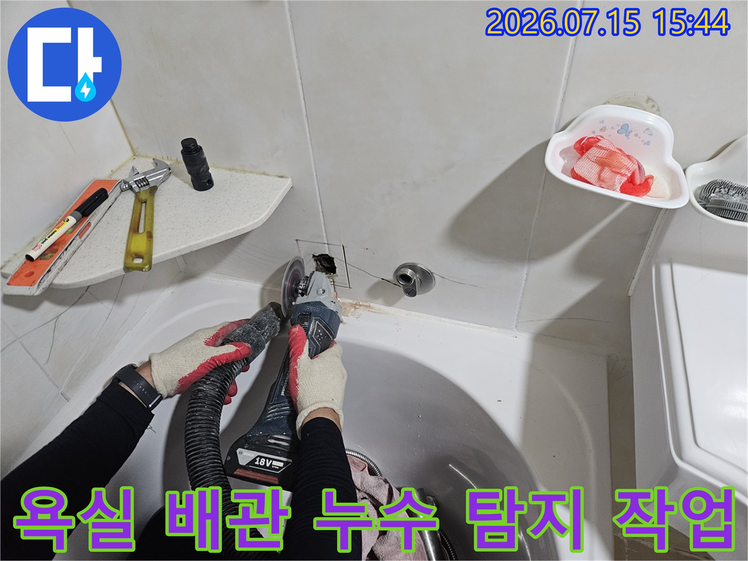 먼지 제거 장비를 사용하여 세면대 하부 노출된 배관 부위를 정밀 점검하는 모습
