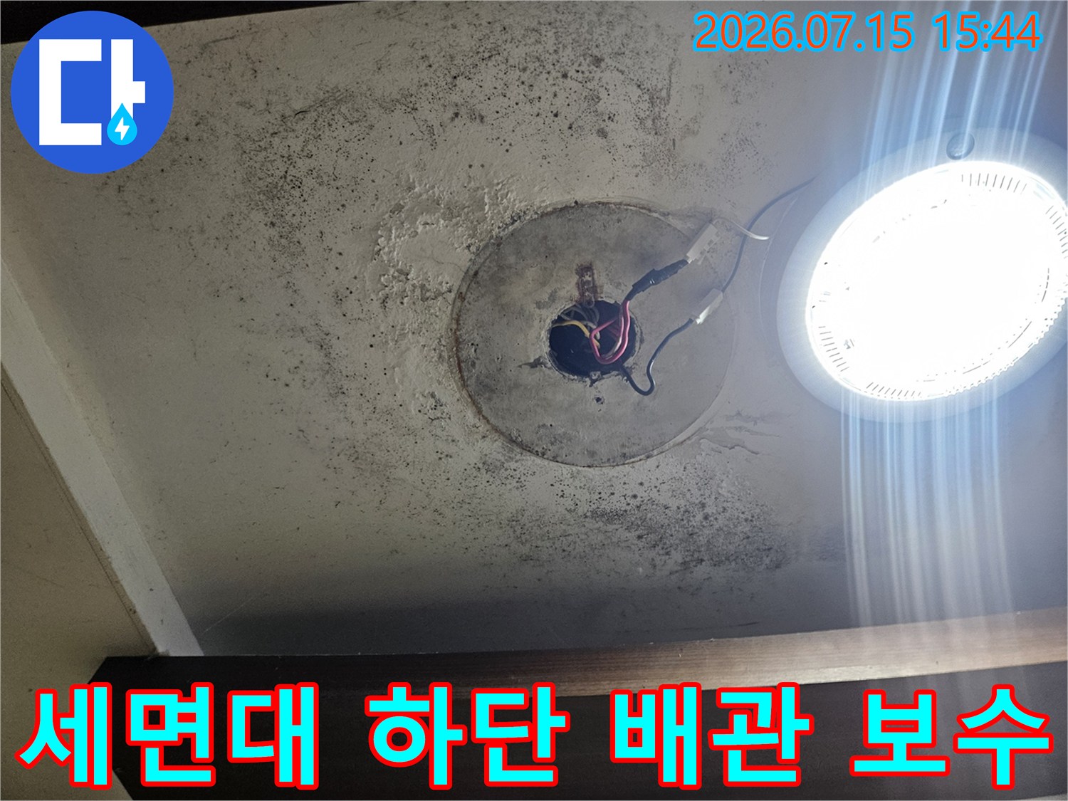 먼지가 쌓인 세면대 하단에서 노출된 파손 배관 수리 모습