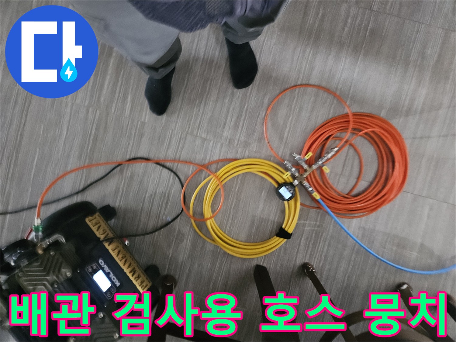 바닥에 놓인 다양한 색상의 배관 점검용 호스와 가스 탐지기-정밀 진단을 위한 장비 구성입니다.