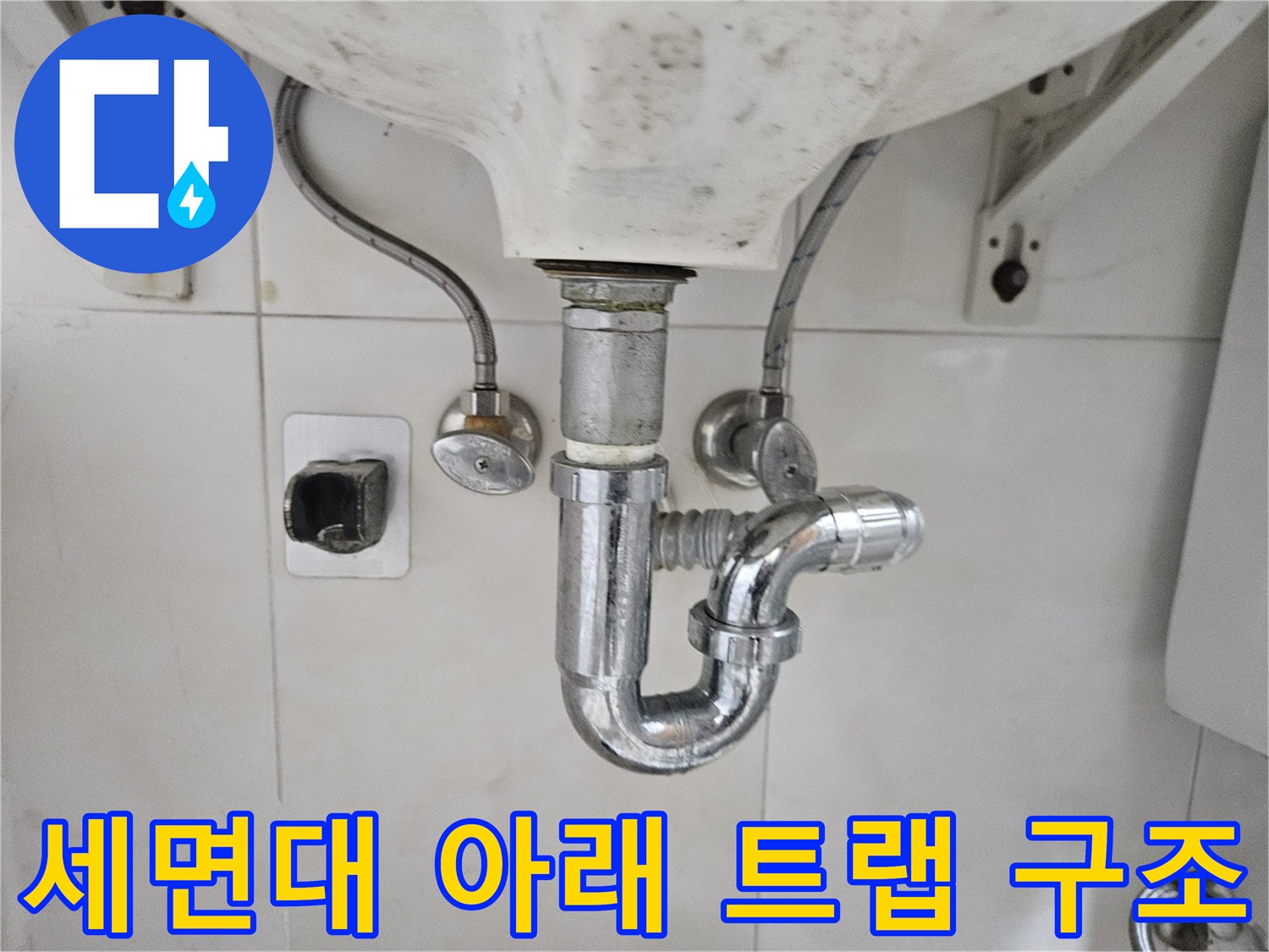 세면대 밑으로 연결된 배수 트랩 및 급수 밸브