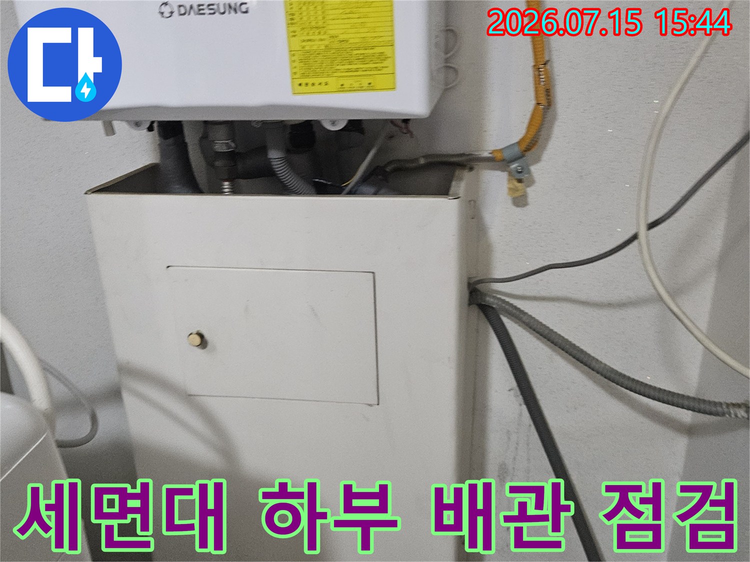 세면대 아래쪽 노출된 온수 및 냉수 배관과 수전 연결 부위를 확인하는 모습