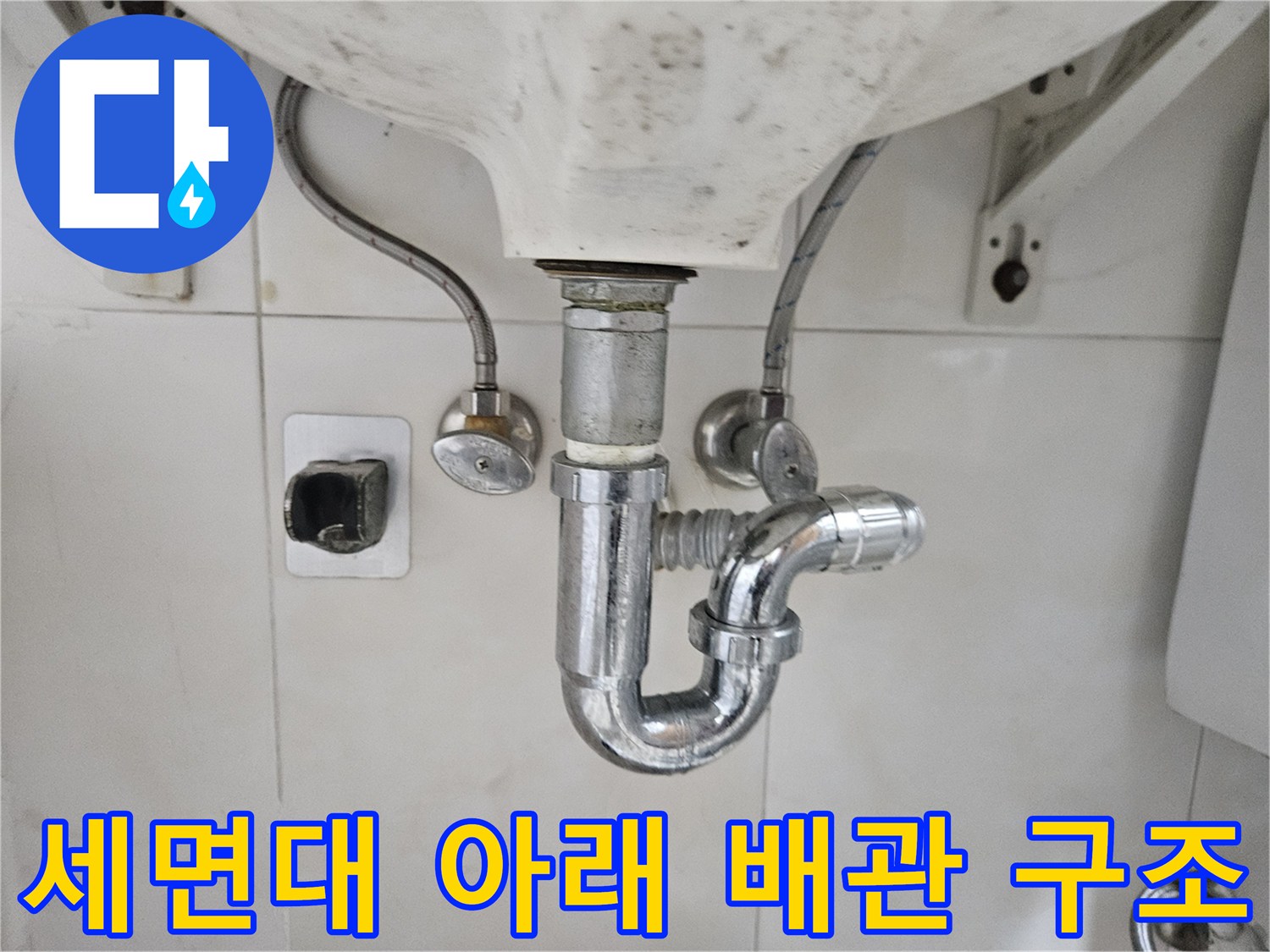 세면대 하단부에 위치한 급수 밸브와 배수 배관