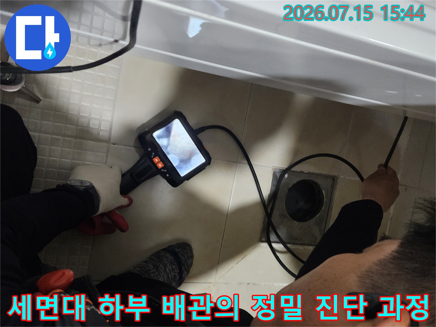 전문가용 탐지 장비를 세면대 아래 배치하여 누수 지점을 찾는 장면