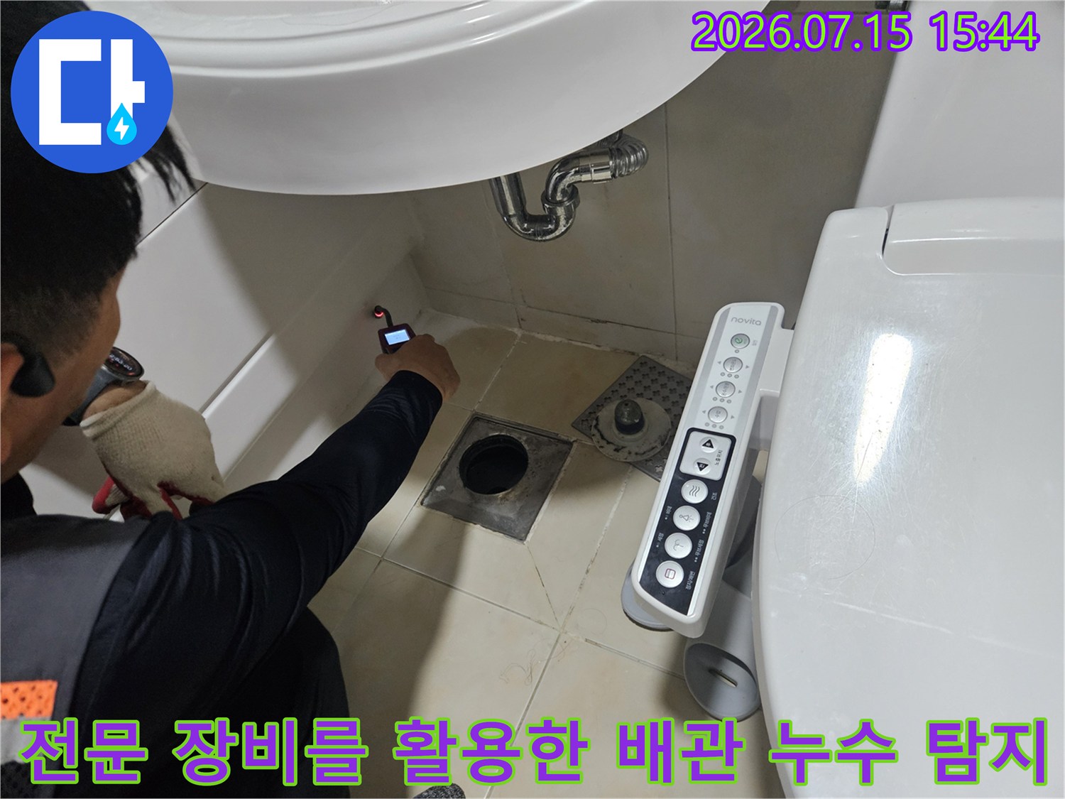 청음식 탐지기를 사용하여 화장실 바닥과 세면대 연결부의 누수 위치를 정밀하게 파악하는 모습
