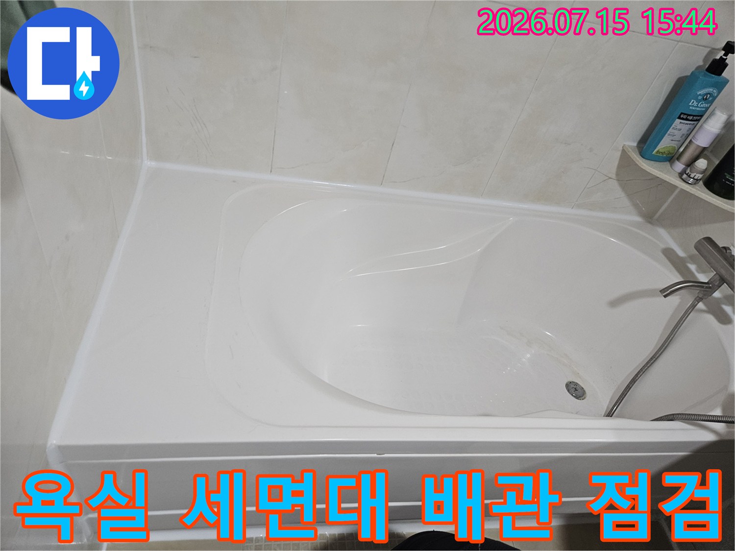 하얀색 욕실 하단부에 위치한 세면대 연결부 및 배관 모습