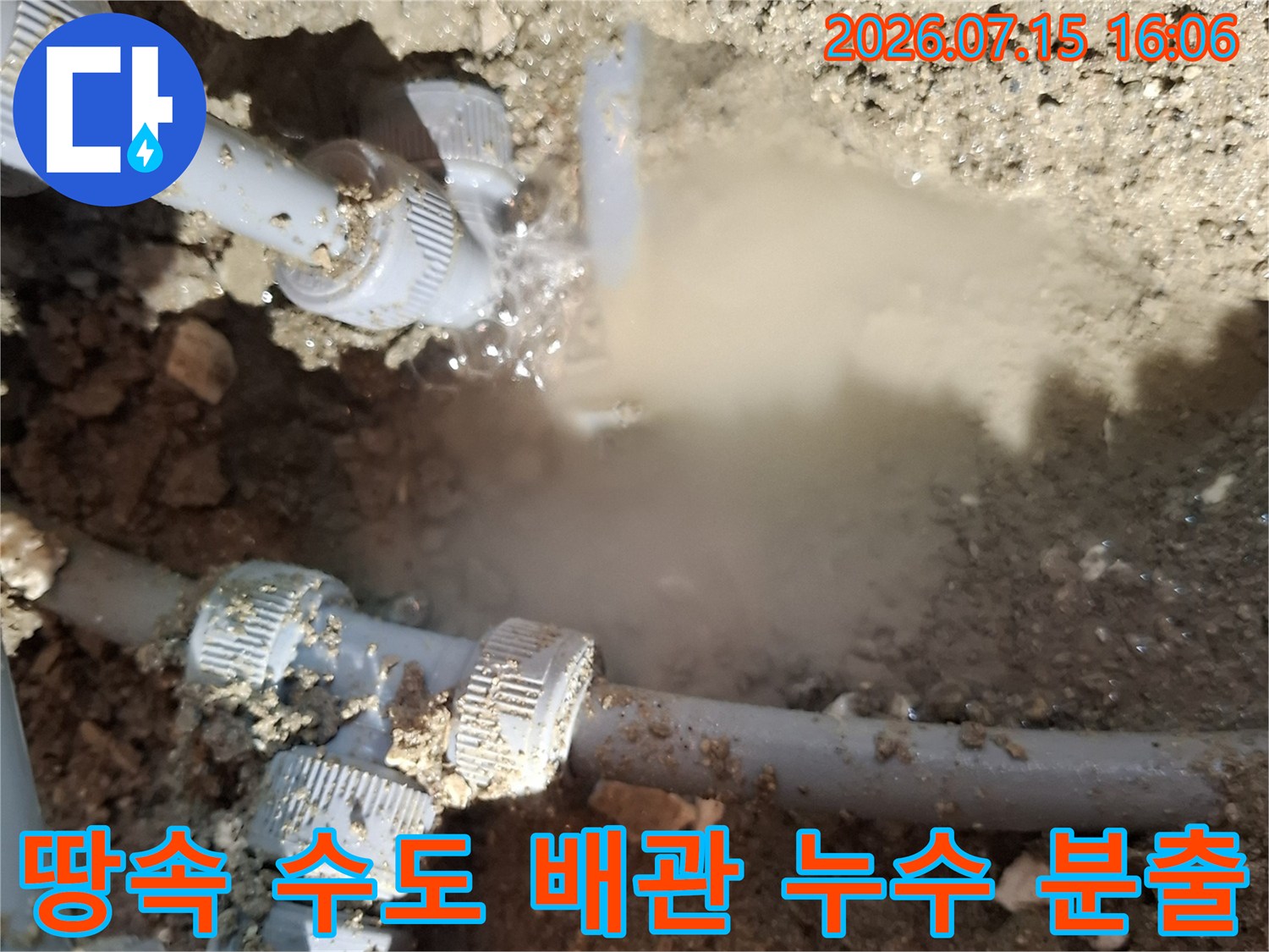 매립된 회색 플라스틱 배관의 연결 커넥터에서 물이 세차게 뿜어져 나오는 모습