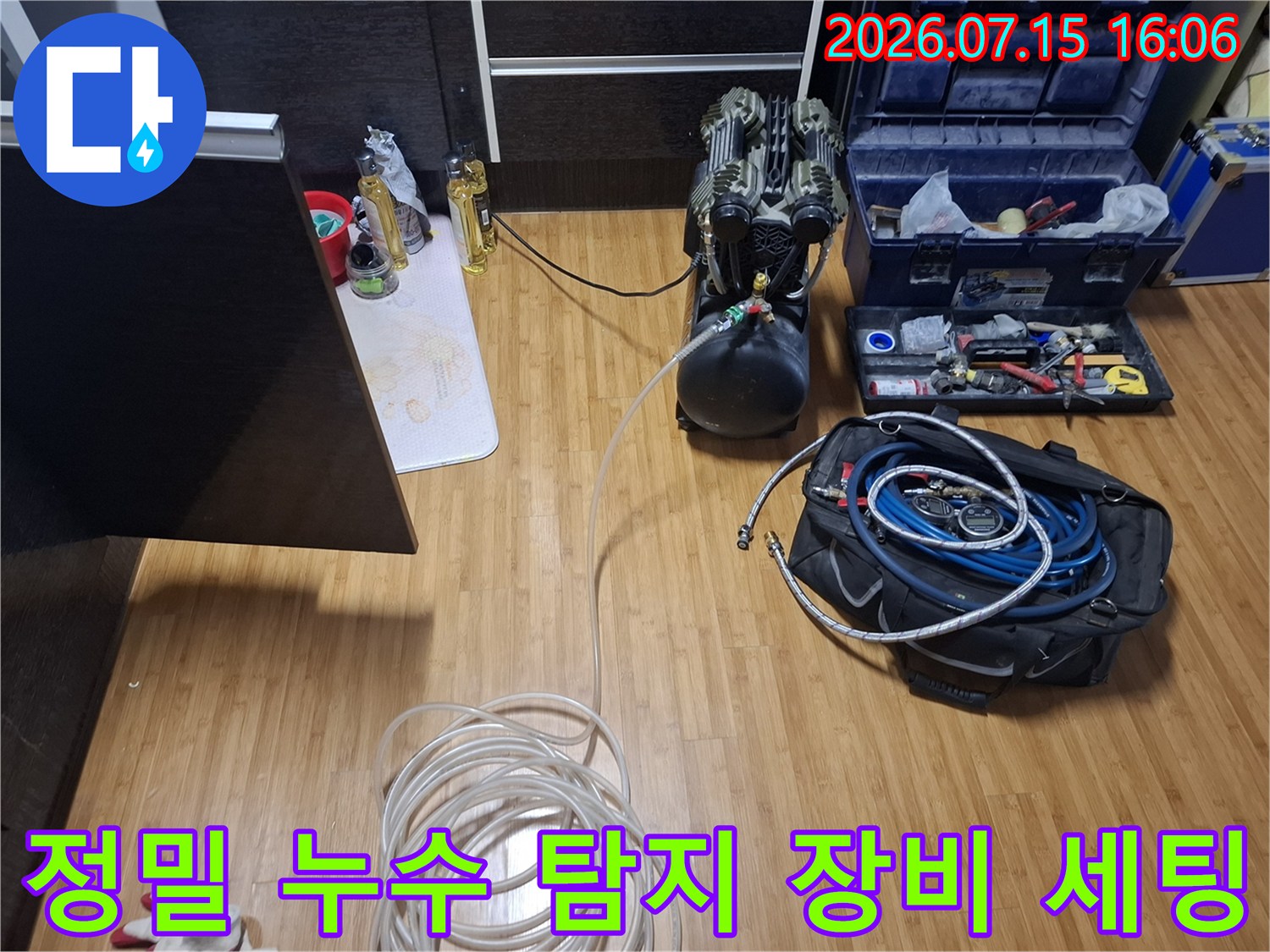 바닥에 놓인 검정색 가스 탐지기와 파란색 호스가 연결된 정밀 누수 진단 장비들