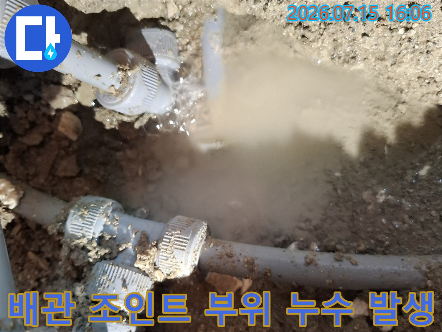 흙과 모래 속에 묻혀 있던 수도 배관의 연결 지점에서 물이 새어 나오는 모습