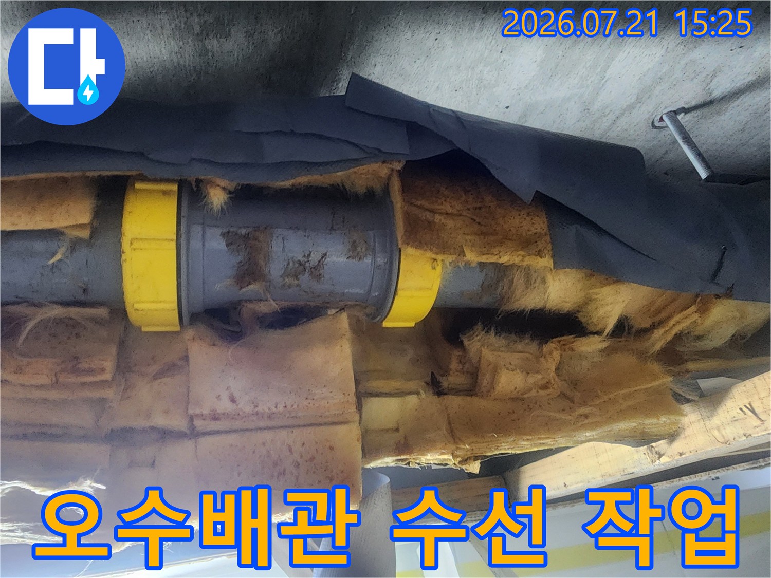 노란색 커플링으로 연결된 배관과 단열재가 노출된 천장 내부 모습