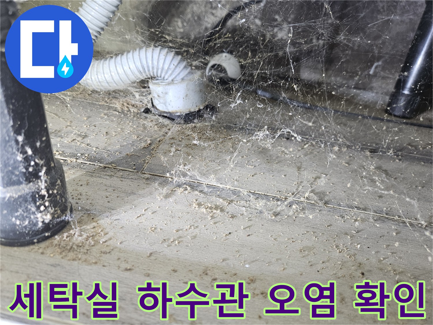 배수 호스 연결 부위의 먼지와 습기가 섞인 상태를 나타냅니다.