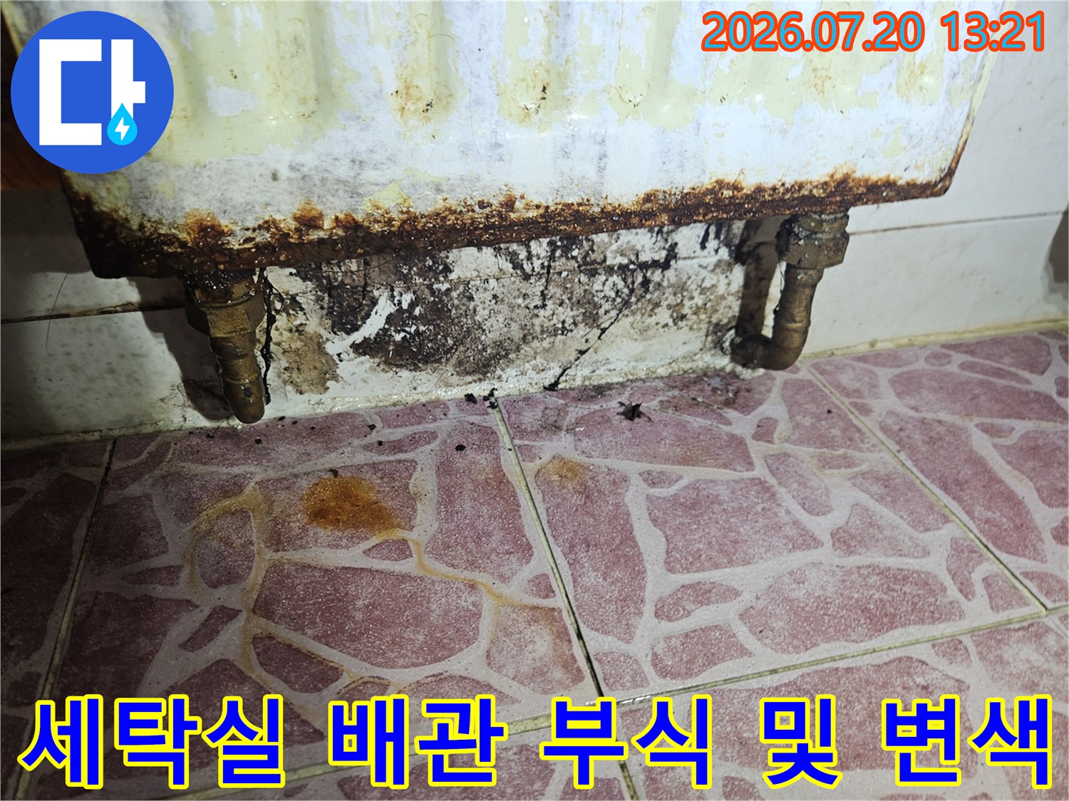 벽면에 묻은 검은 오염과 노출된 파이프의 부식 상태를 촬영한 사진