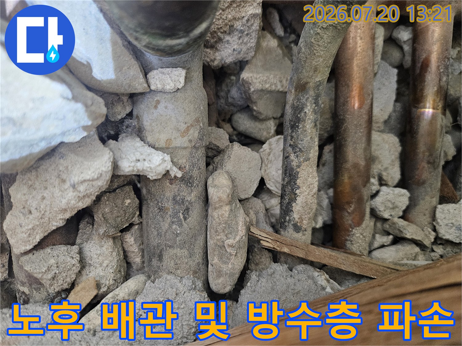 오염된 흙과 콘크리트 사이에 노출된 노후 배관 상태