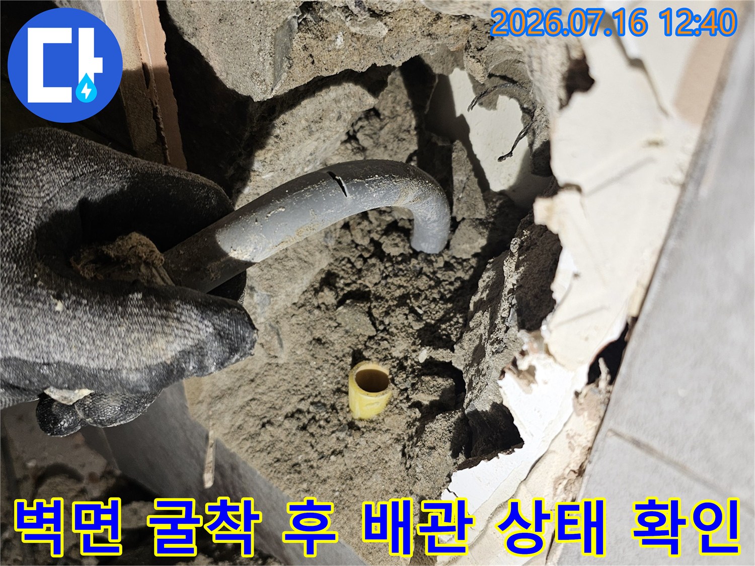 타일을 제거하고 내부의 손상된 배관 부위를 노출시킨 모습