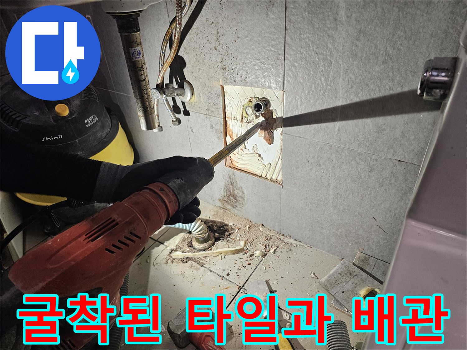 타일을 제거하여 드러난 벽면 배관의 연결 상태와 주변 환경입니다.