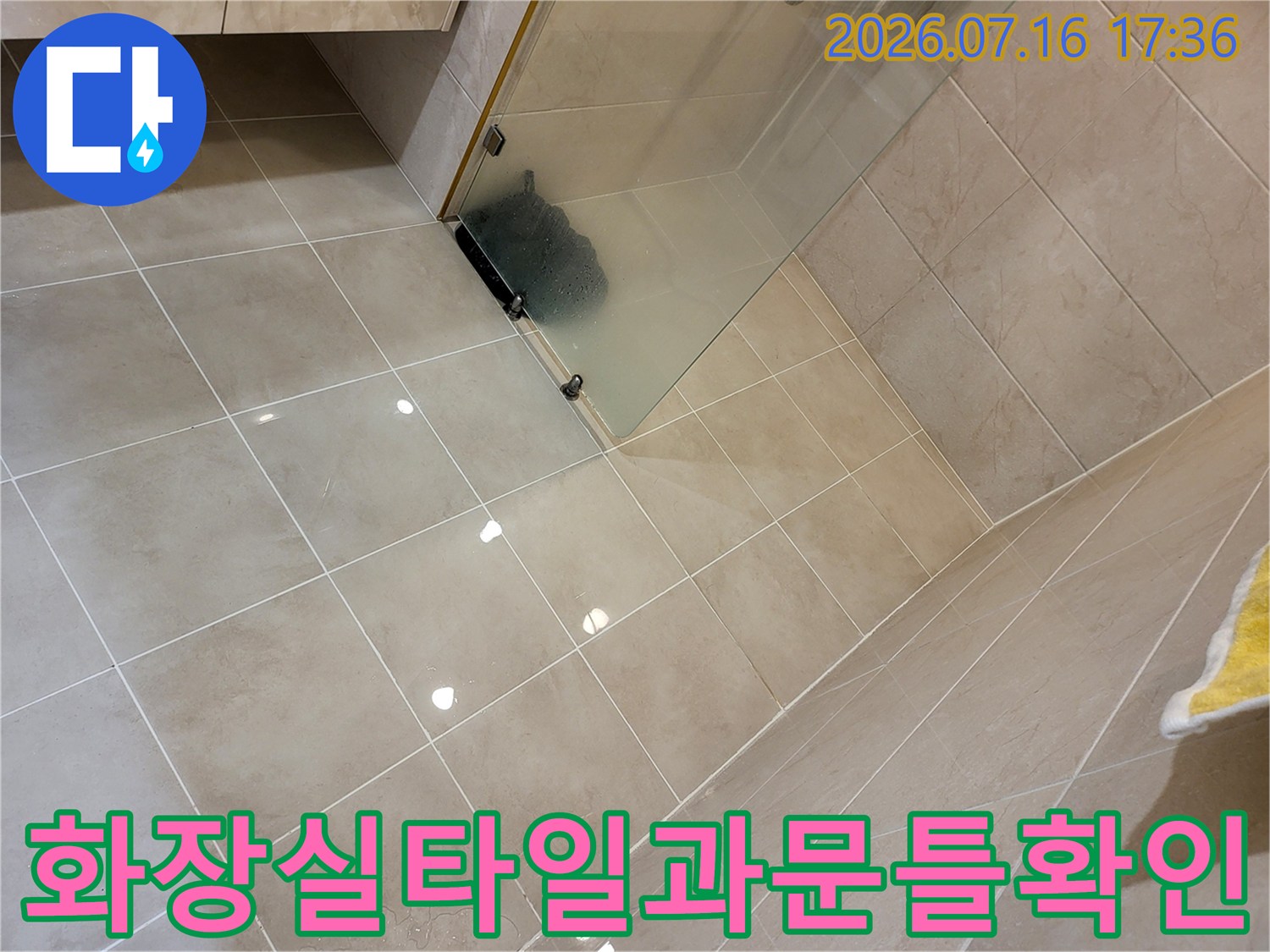 회색톤의 타일로 마감된 샤워실 내부와 유리문이 설치된 모습