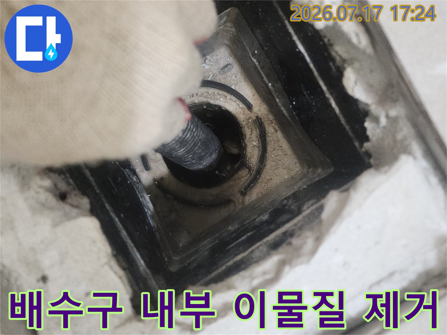 노출된 배수구 구멍에 석션 호스를 연결하여 세척하는 장면
