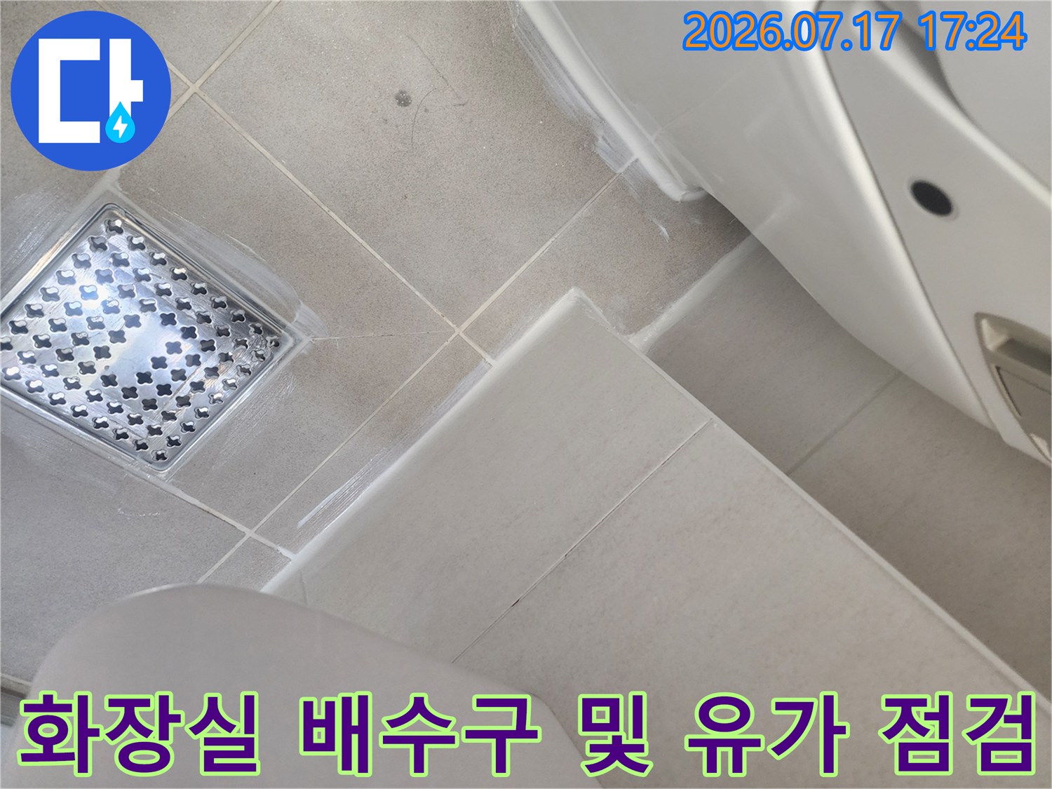 스테인리스 재질의 화장실 유가와 주변 타일 마감 상태를 촬영한 사진입니다.