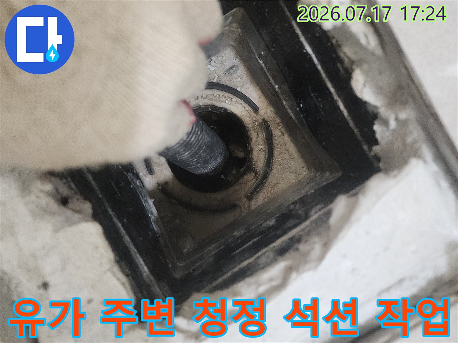 전문 장비를 사용하여 화장실 배수구 내의 오염물질을 제거하는 모습