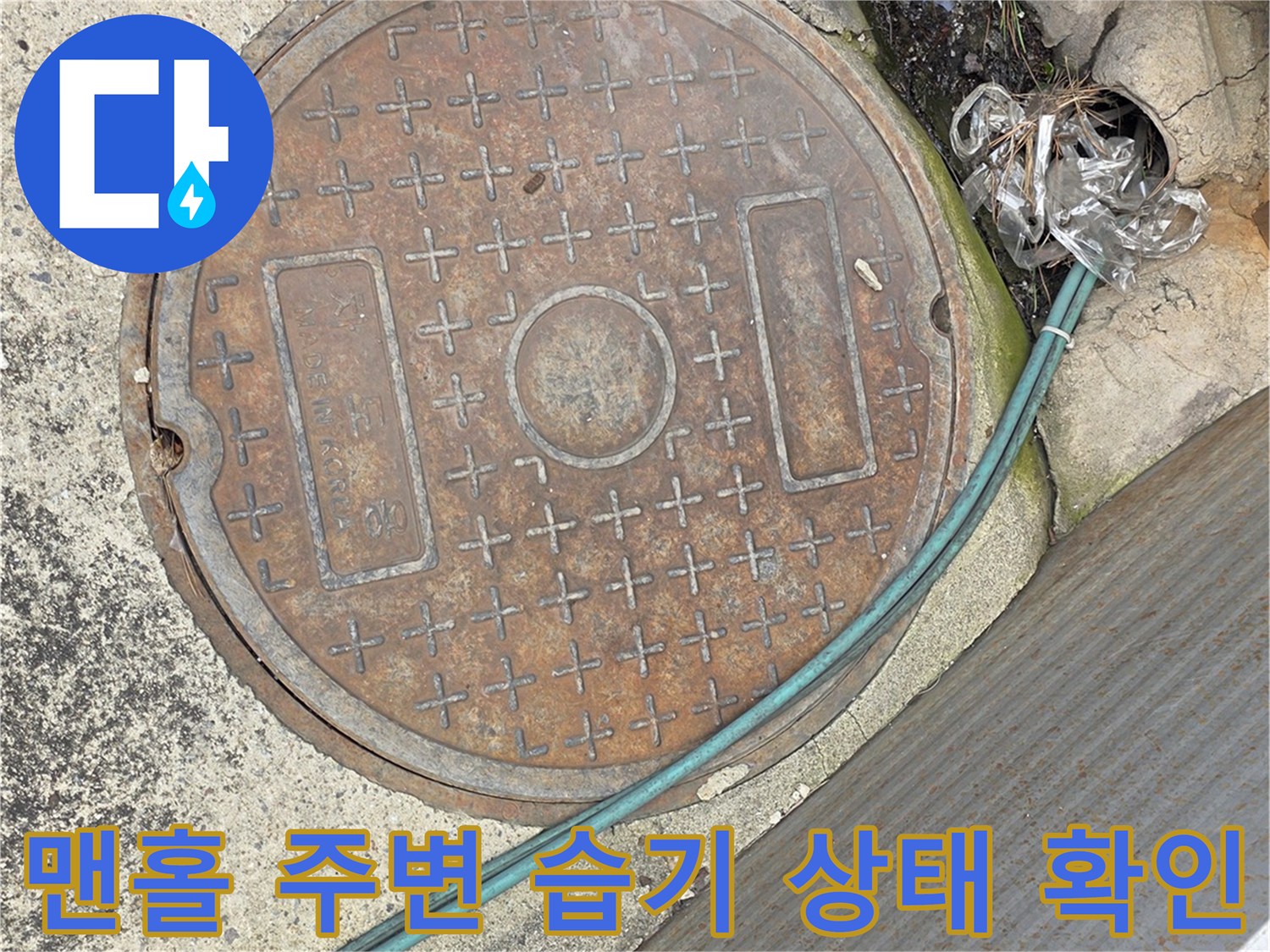 맨홀 뚜껑 주변의 물에 젖은 바닥과 배관 연결 부위