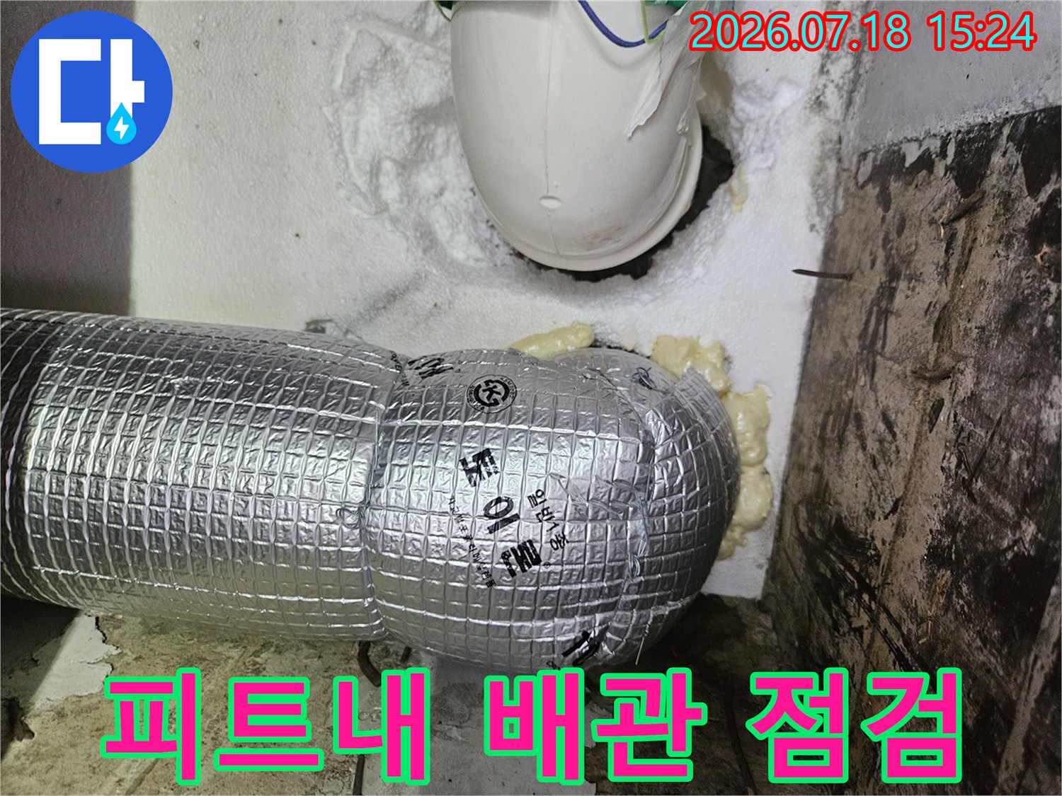 보온재로 감싸인 은색 배관과 상부 파이프 연결 부위 점검 모습