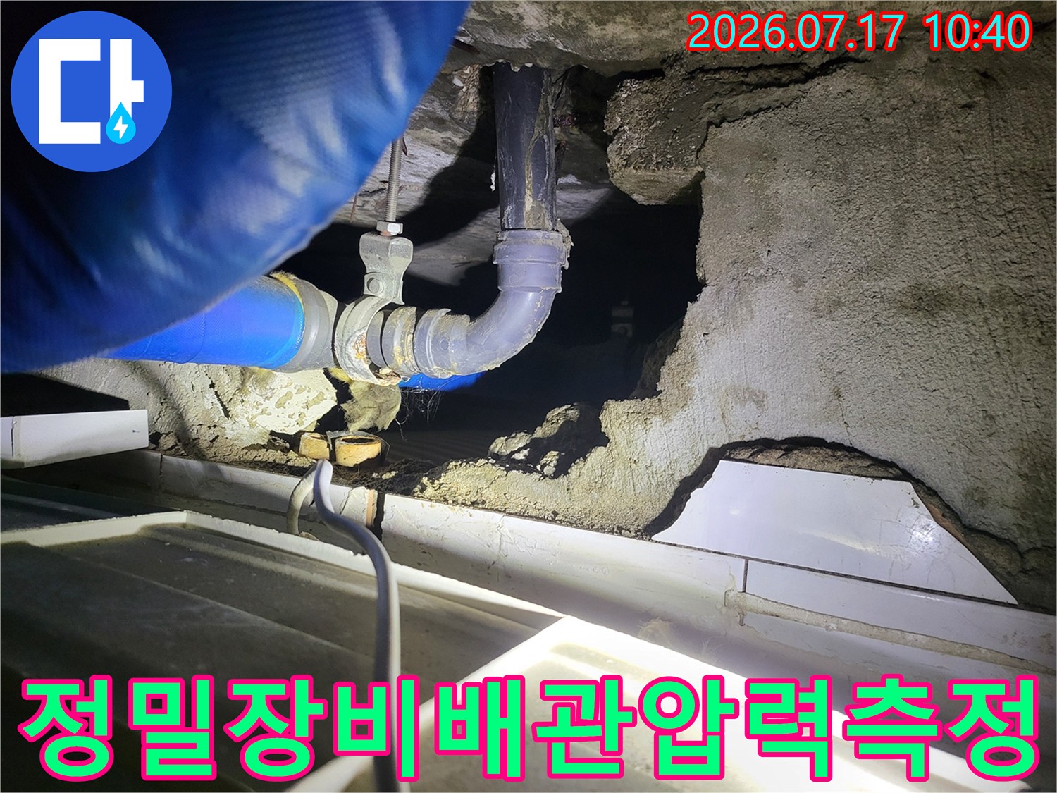 노출된 배관에 측정용 호스를 연결하여 누수 여부를 분석하는 현장 사진