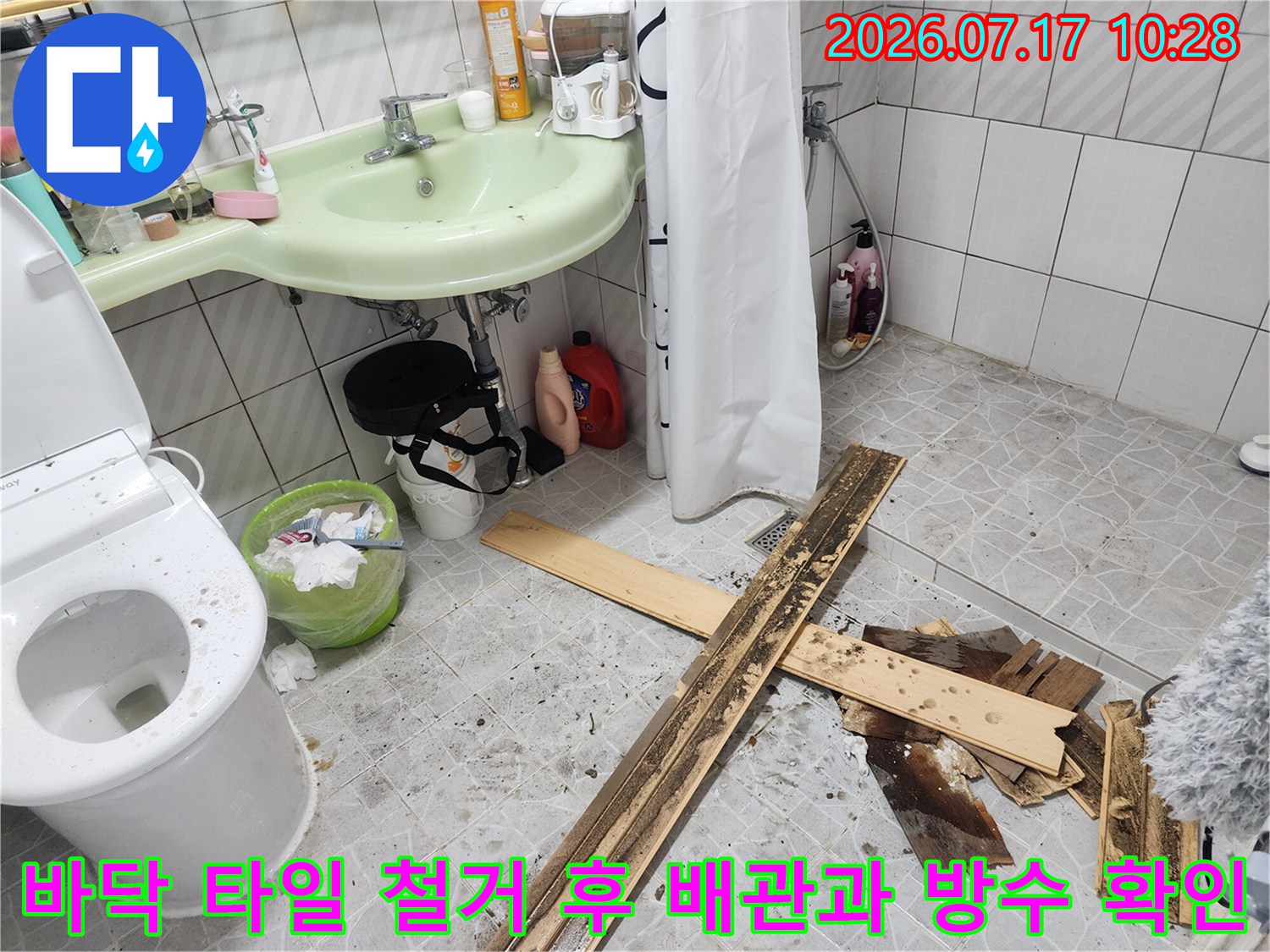 누수가 발생하는 지점의 바닥을 파내어 배관 연결부와 하부 구조를 노출시킨 작업 장면입니다.