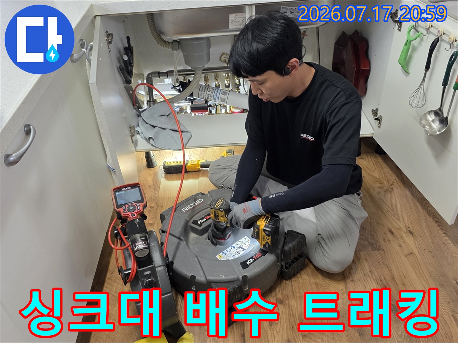 싱크대 아래 공간에서 정밀 장비를 사용하여 배수 경로를 추적하는 장면