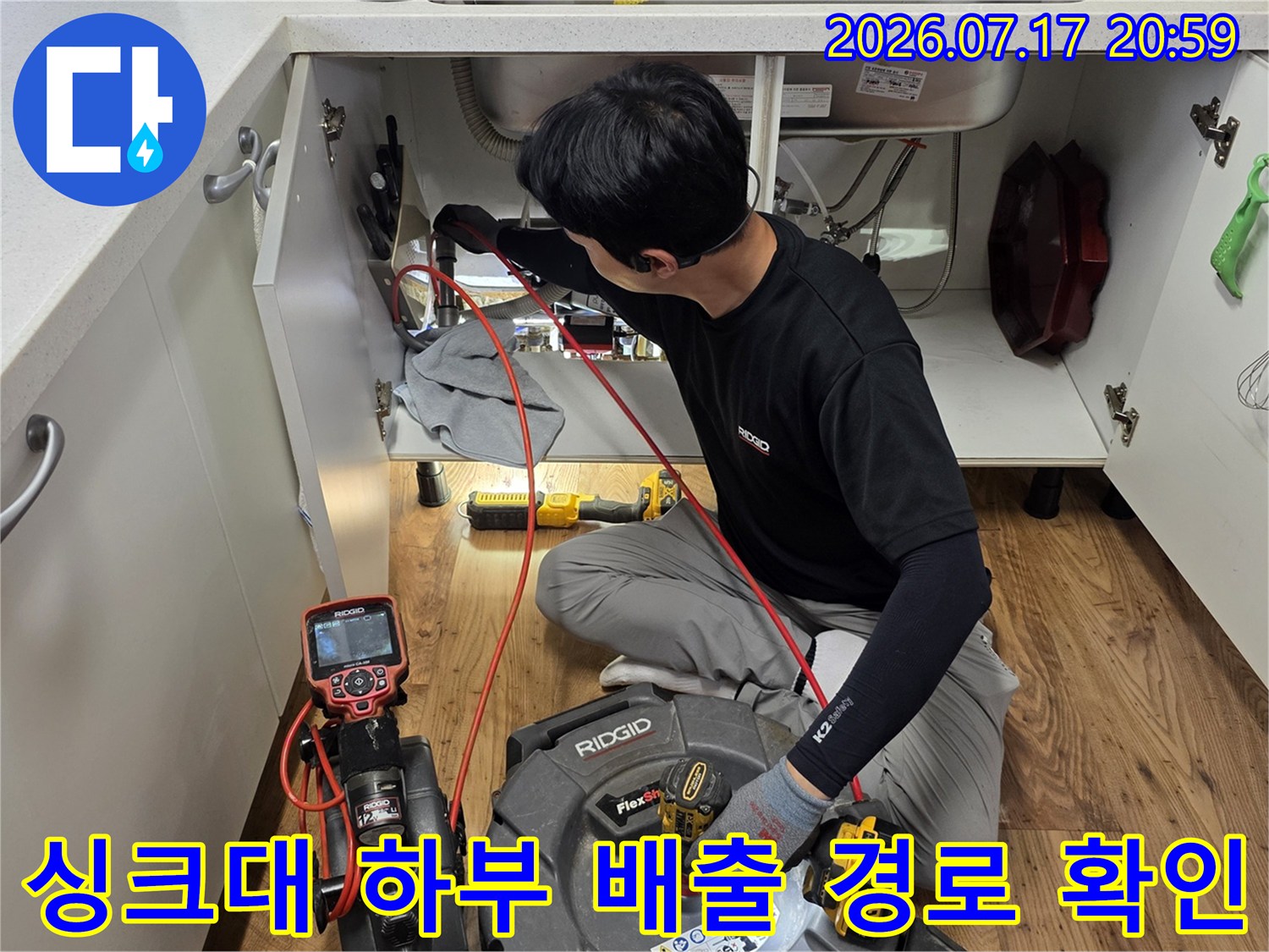 장비를 연결하여 싱크대 아래 배관을 면밀히 조사하는 과정