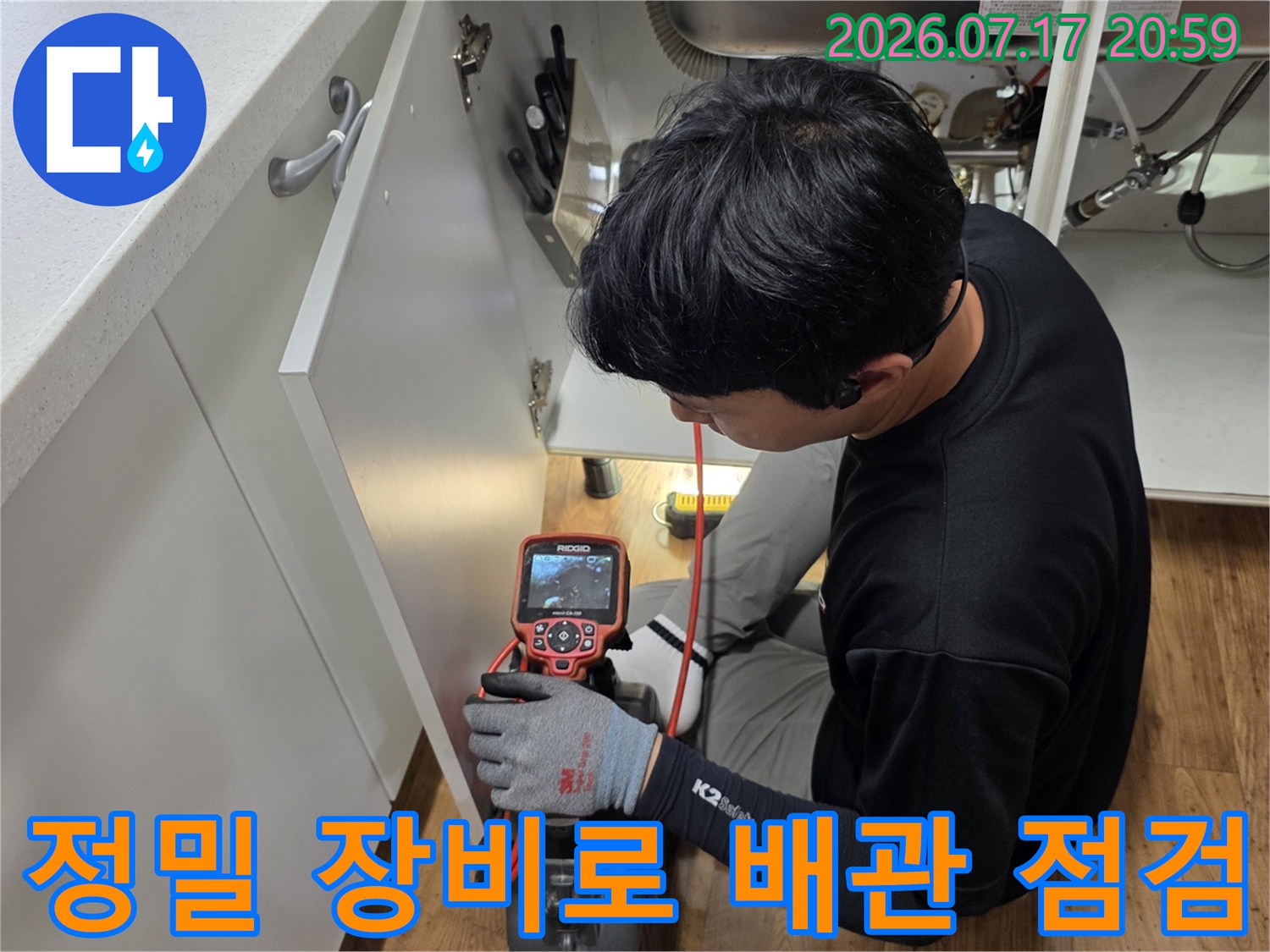 전문가가 특수 장비를 사용하여 싱크대 하부 배관 상태를 세밀하게 확인하는 모습