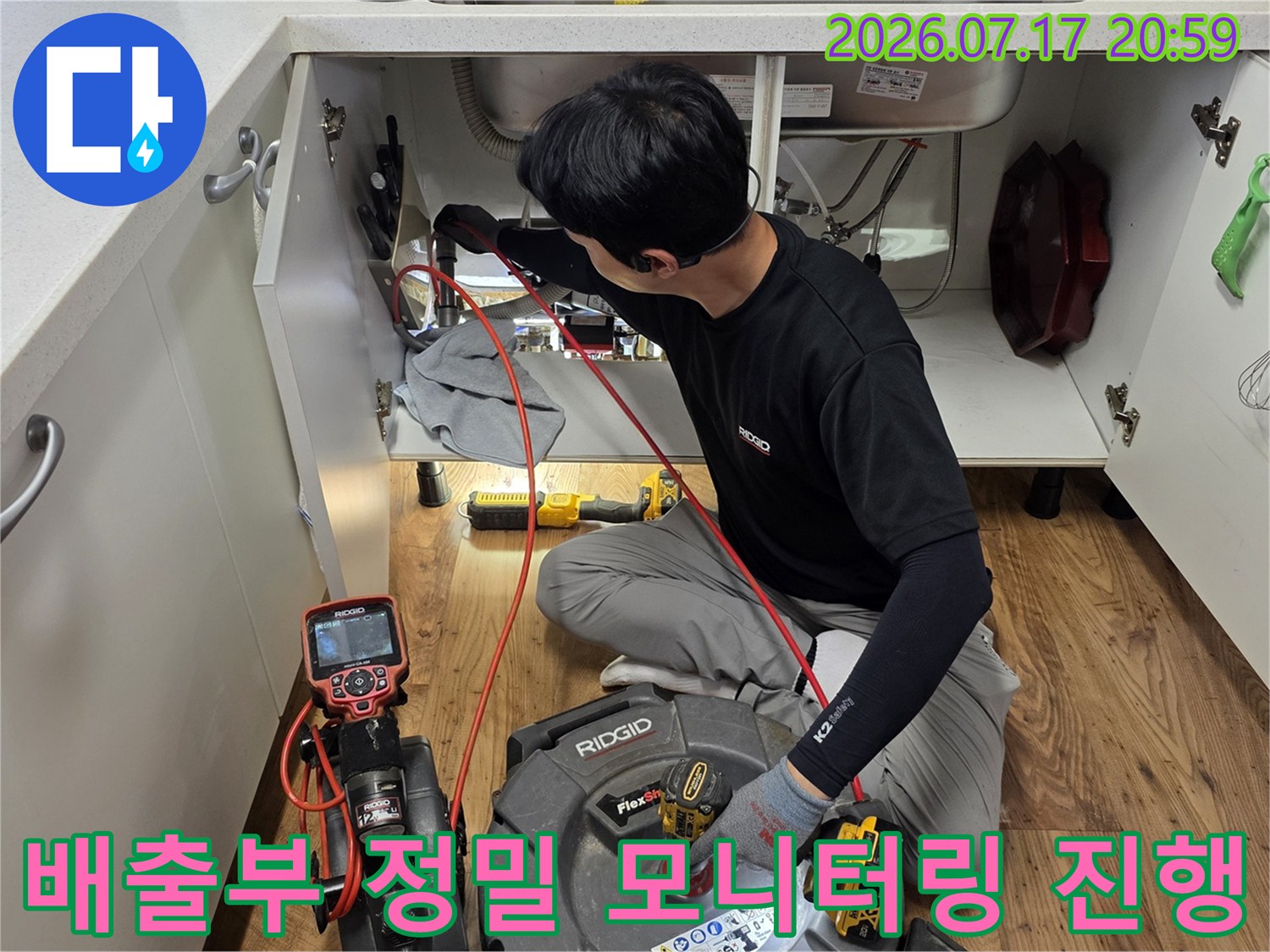 특수 장비를 통해 싱크대 하부 배관의 상태를 상세히 분석하는 기술자 모습