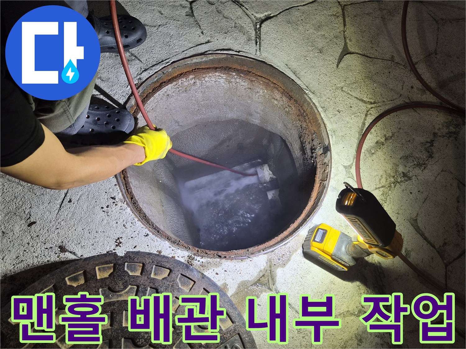 맨홀 안쪽 고여 있는 물과 투입된 배관 청소 장비