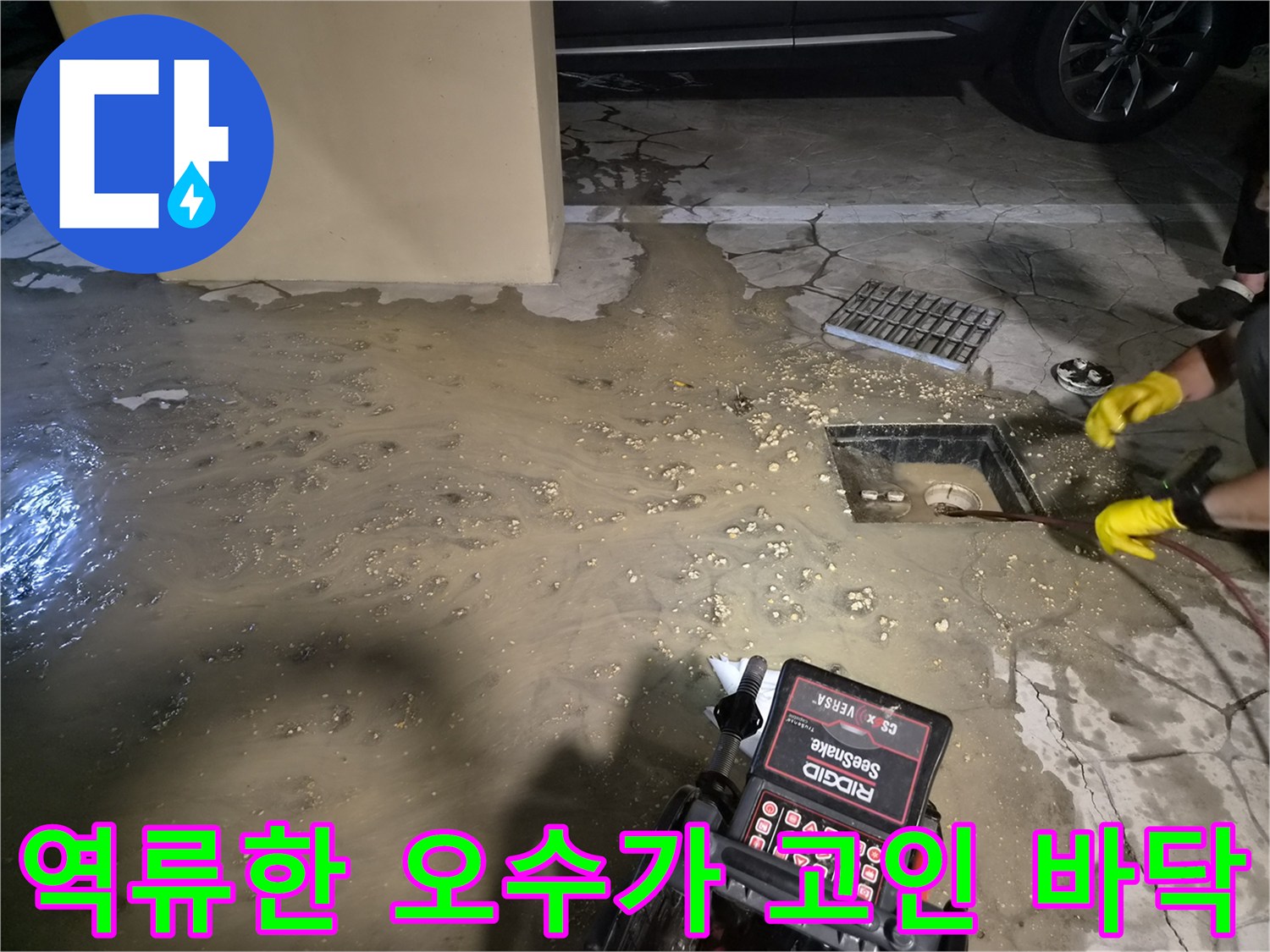맨홀 주변에 역류하여 넓게 퍼진 오수와 작업 장비