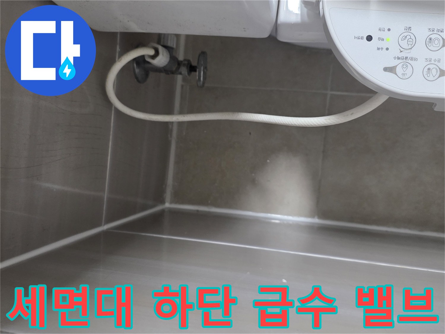 화장실 세면대 아래에 위치한 수도 조절 밸브와 호스 연결부입니다.
