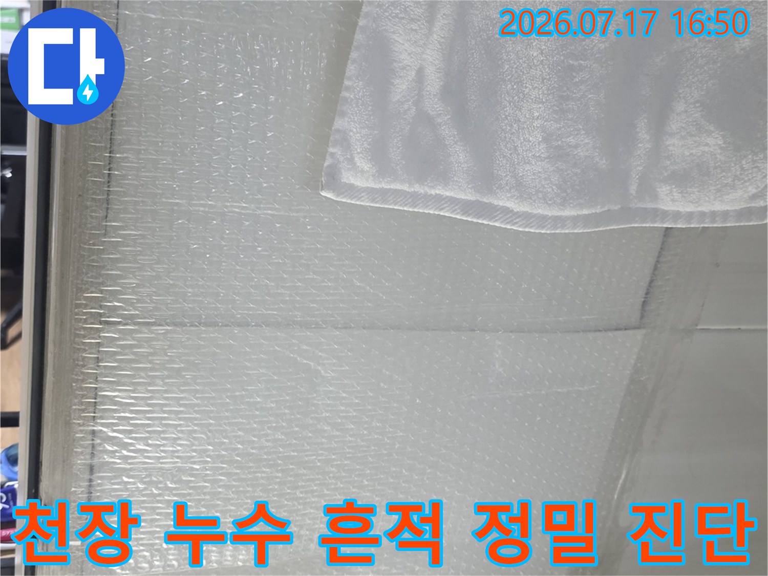 흰색-타일-천장의-누수-흔적과-습기가-맺힌-부분을-근접-촬영한-사진