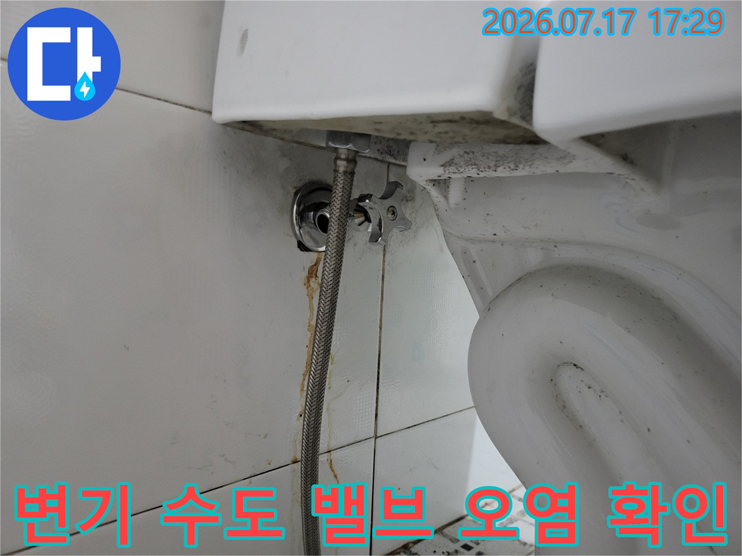 벽면-타일에-설치된-금속제-급수-밸브와-연결-호스