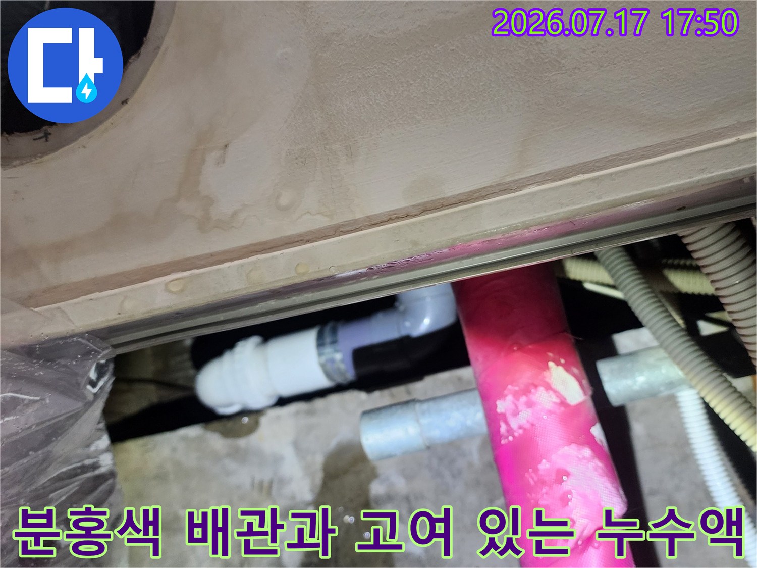 콘크리트 천장 슬라브 위에 물이 고여 있고 분홍색 보온재 배관이 지나가는 모습
