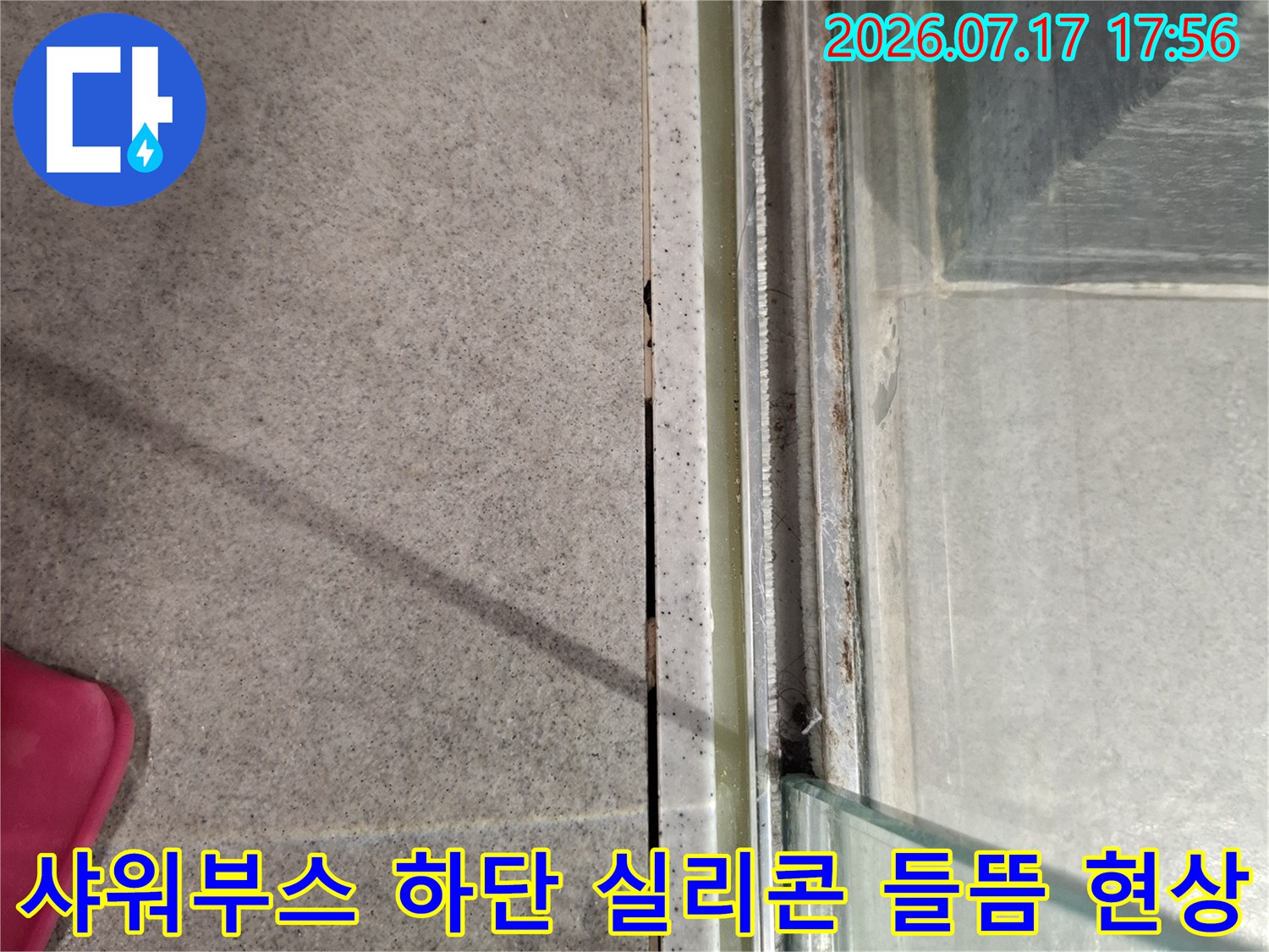 샤워-부스-하단-레일과-타일의-경계면에서-실리콘이-들떠서-벌어진-모습