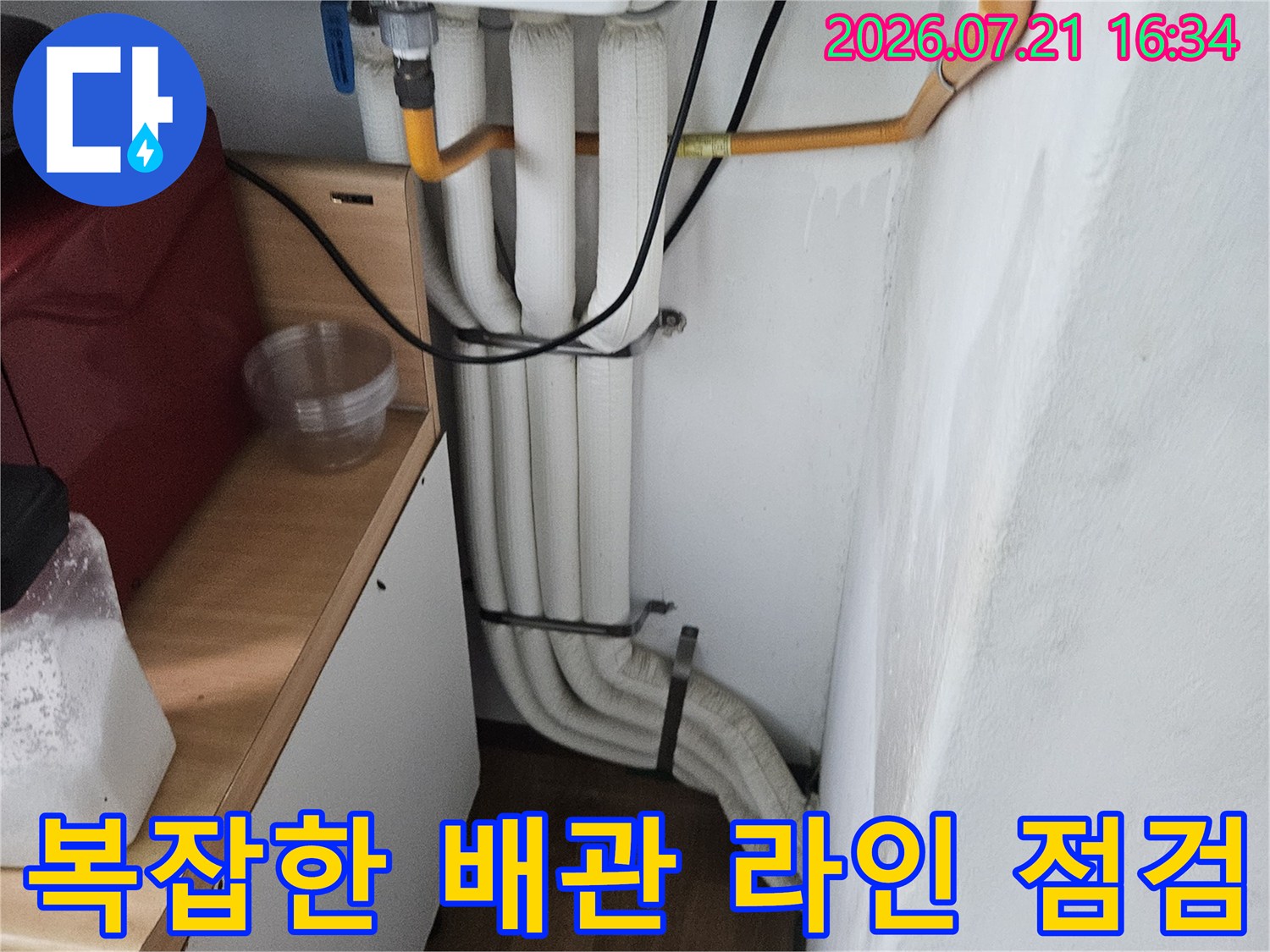 좁은 공간에 설치된 다수의 노출 배관과 세면대 구조물 점검