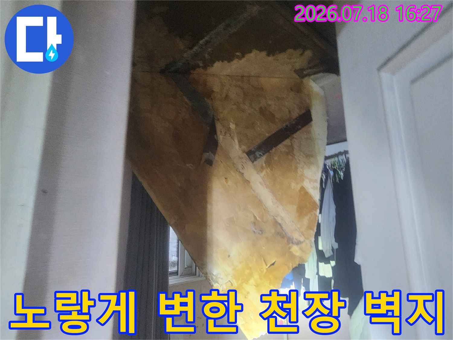 물기가 스며들어 노란색으로 얼룩진 천장 마감재의 근접 사진