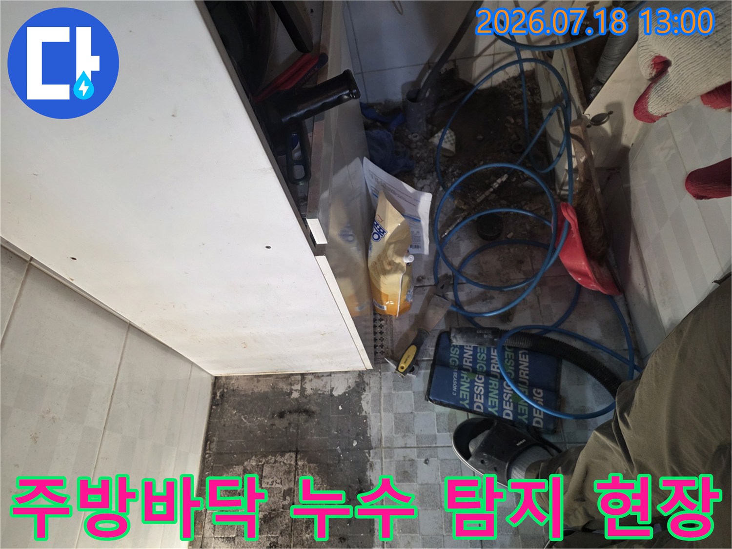 싱크대 하단 타일 바닥에 푸른색 배관이 엉켜있고 오염된 모습-누수 진단 과정
