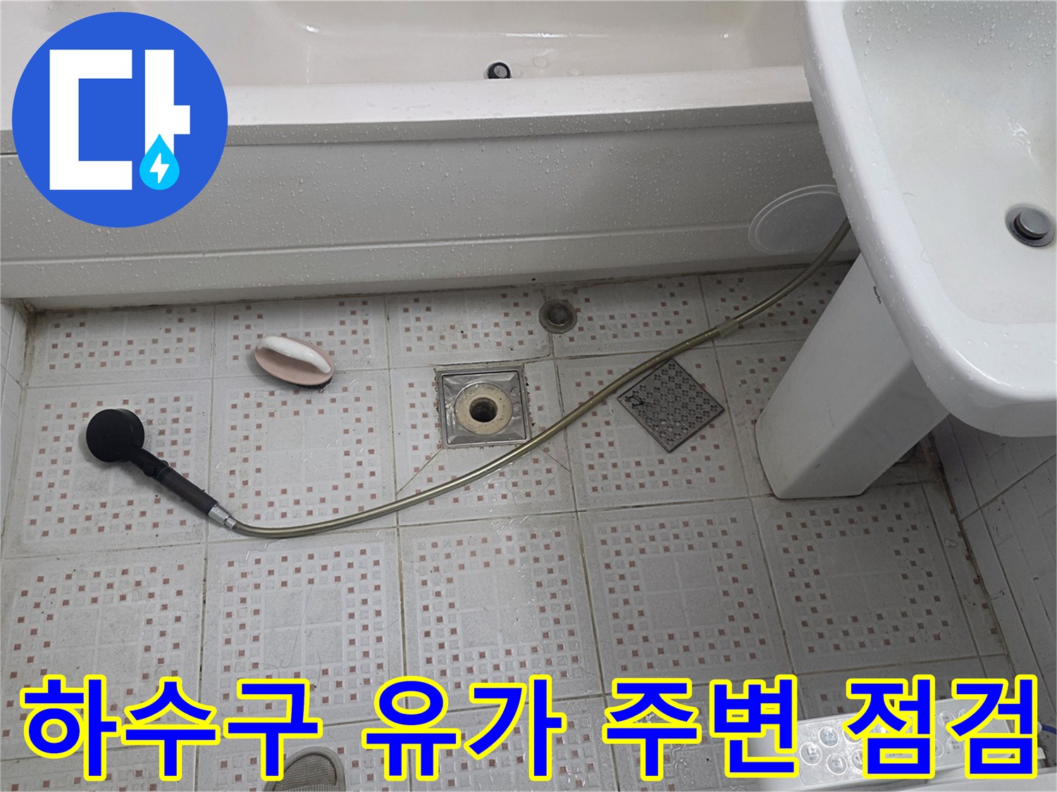 세면대 아래 샤워기 호스와 하수구 입구의 타일 마감 상태를 나타내는 이미지