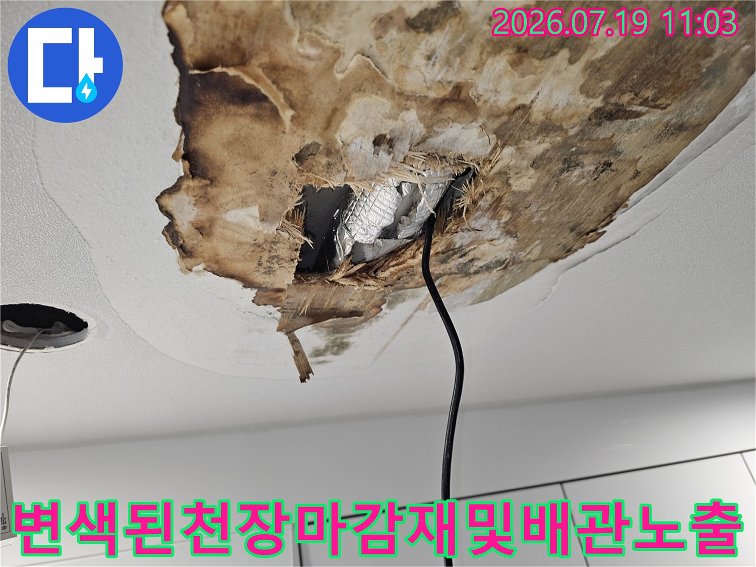 물에 젖어 갈색으로 변하고 처진 천장-뜯어진 틈 사이로 보이는 은색 보온재